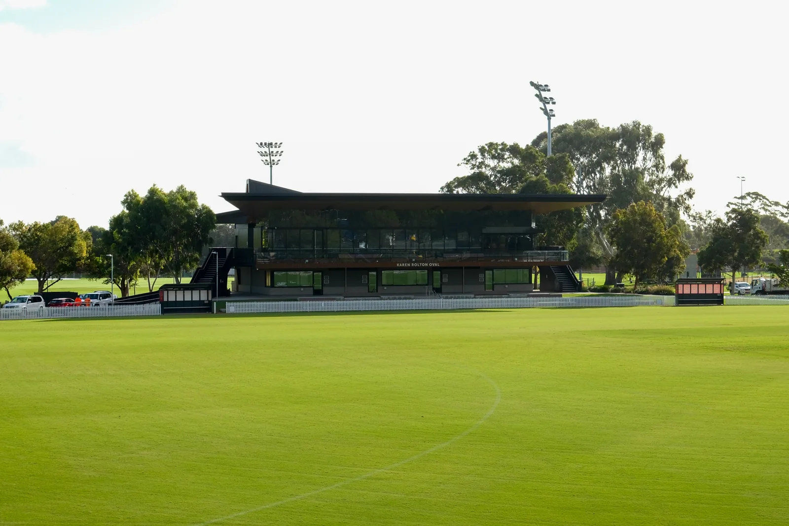 Karen Rolton Oval pavilion and green cricket outfield in Adelaide, viewed from beyond the boundary